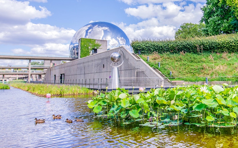Exterior view of Science & Industry Museum with geodesic dome and pond, Paris, France.
