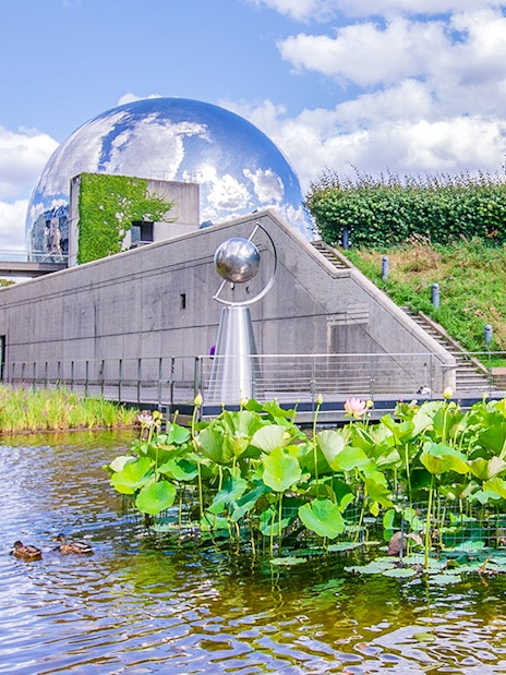 Exterior view of Science & Industry Museum with geodesic dome and pond, Paris, France.