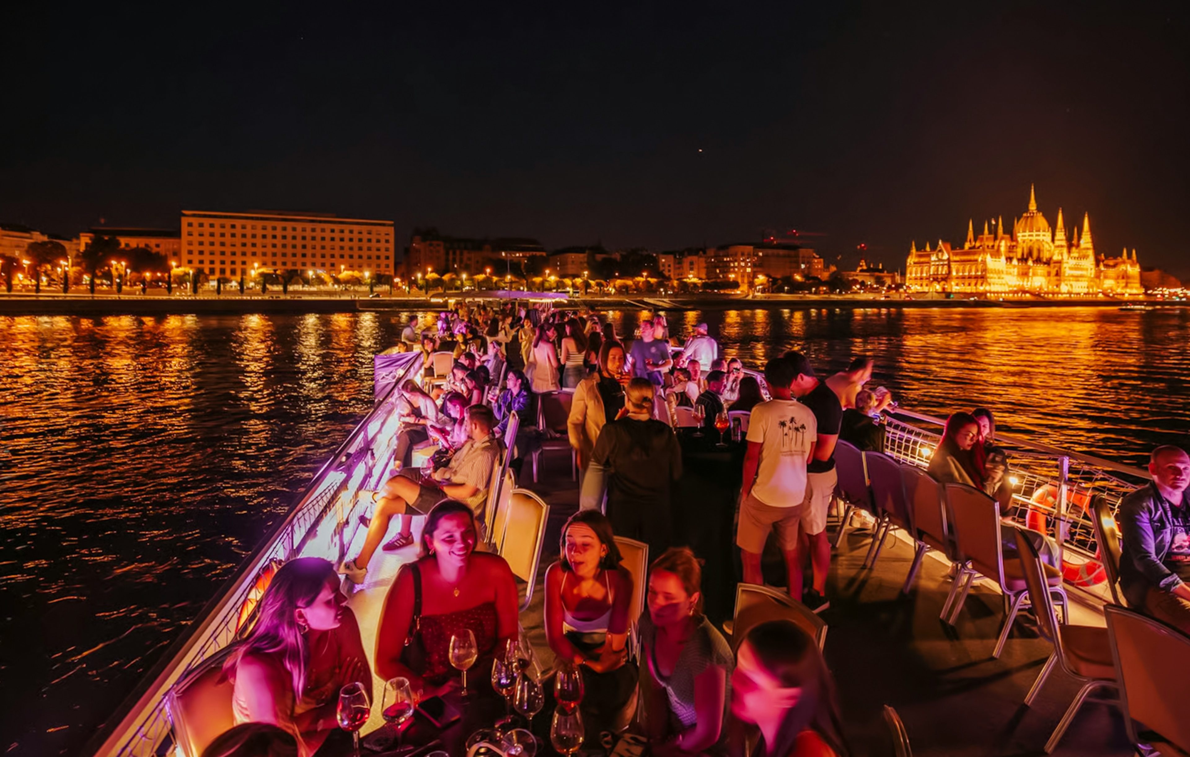Cruise guests enjoying a night view of Budapest Parliament from the Danube River.