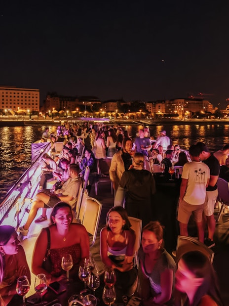 Cruise guests enjoying a night view of Budapest Parliament from the Danube River.