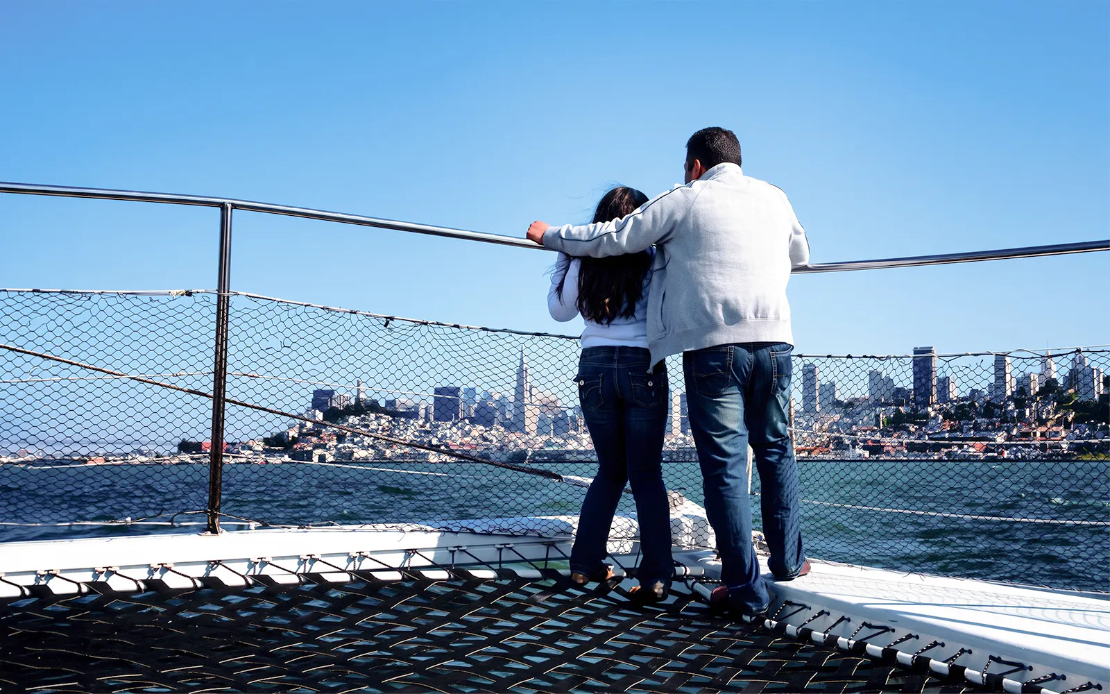 Guests on a sailing cruise enjoying San Francisco Bay skyline views.