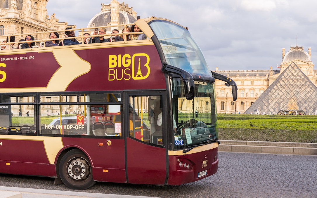 Tourists on Big Bus tour near the Louvre Pyramid in Paris.