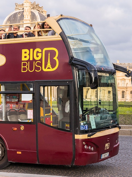 Tourists on Big Bus tour near the Louvre Pyramid in Paris.