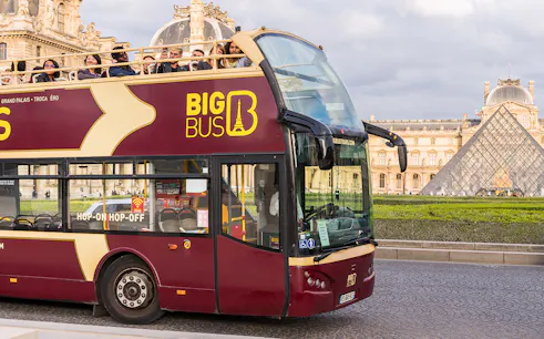 Tourists on Big Bus tour near the Louvre Pyramid in Paris.