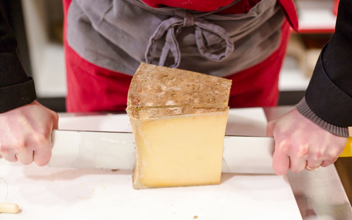 Cutting cheese at the Cheese Museum in Paris, France.
