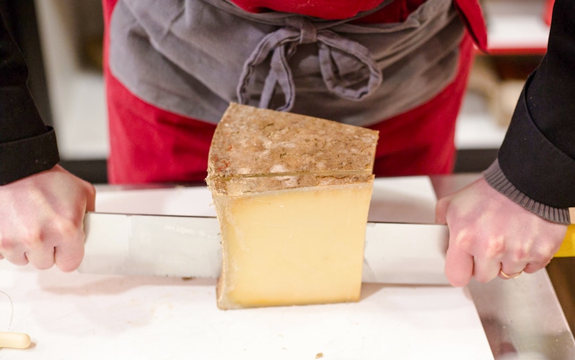Cutting cheese at the Cheese Museum in Paris, France.