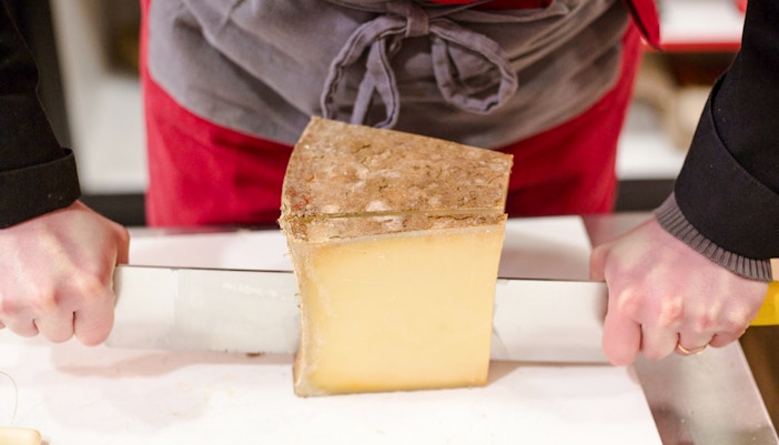 Cutting cheese at the Cheese Museum in Paris, France.