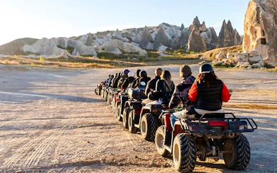 ATV riders exploring Cappadocia's rocky landscape during a tour.
