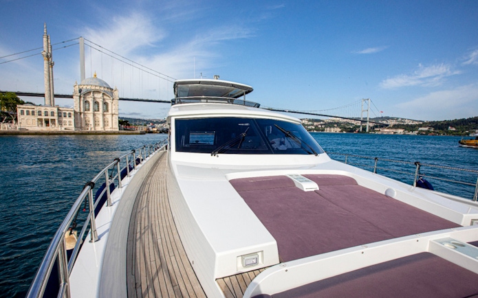 Bosphorus cruise boat with Ortaköy Mosque and Bosphorus Bridge in Istanbul.