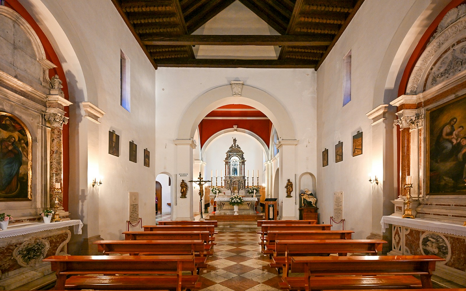 Interior of St. Francis Church Monastery in Split, featuring wooden pews and ornate altar.