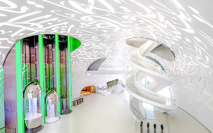 Futuristic interior of Museum of the Future in Dubai with spiral staircase and illuminated walls.