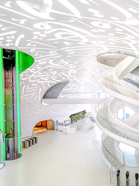 Futuristic interior of Museum of the Future in Dubai with spiral staircase and illuminated walls.