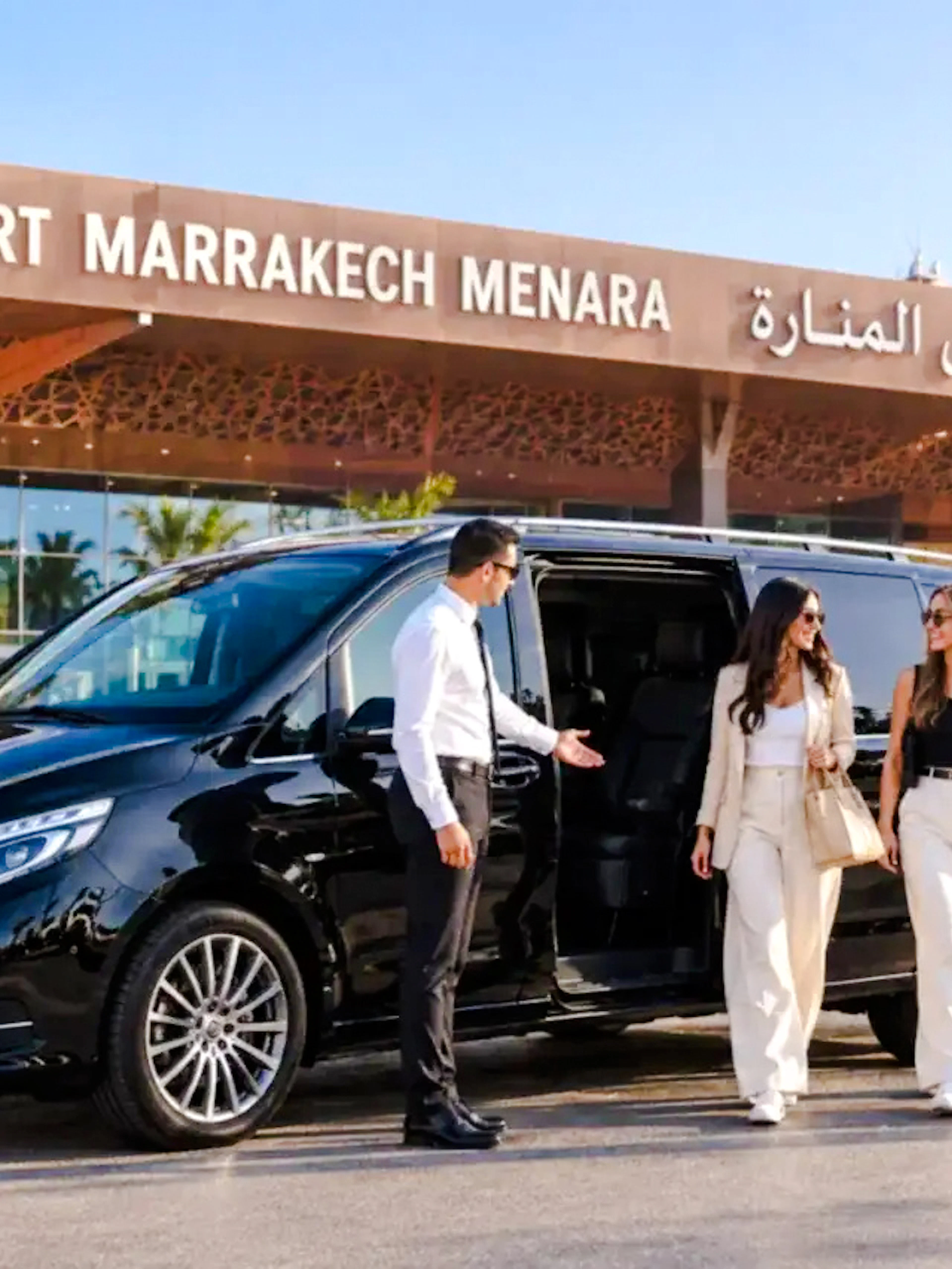 Private transfer service at Marrakech Menara Airport with a luxury van and driver assisting passengers.