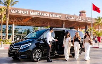 Private transfer service at Marrakech Menara Airport with a luxury van and driver assisting passengers.