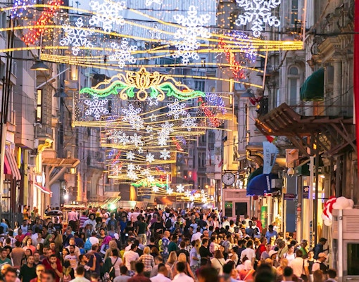 Istiklal Street bustling with New Year celebrations in Istanbul, featuring festive lights and crowds.