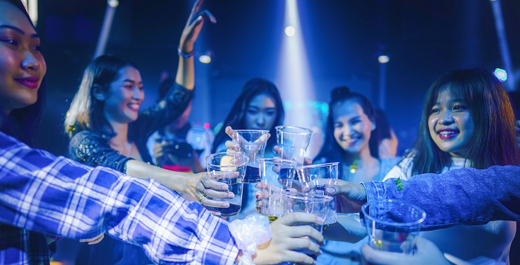Group of friends toasting drinks during a Singapore pub crawl.