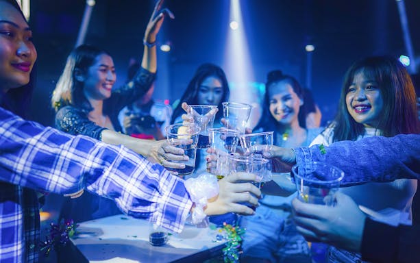 Group of friends toasting drinks during a Singapore pub crawl.