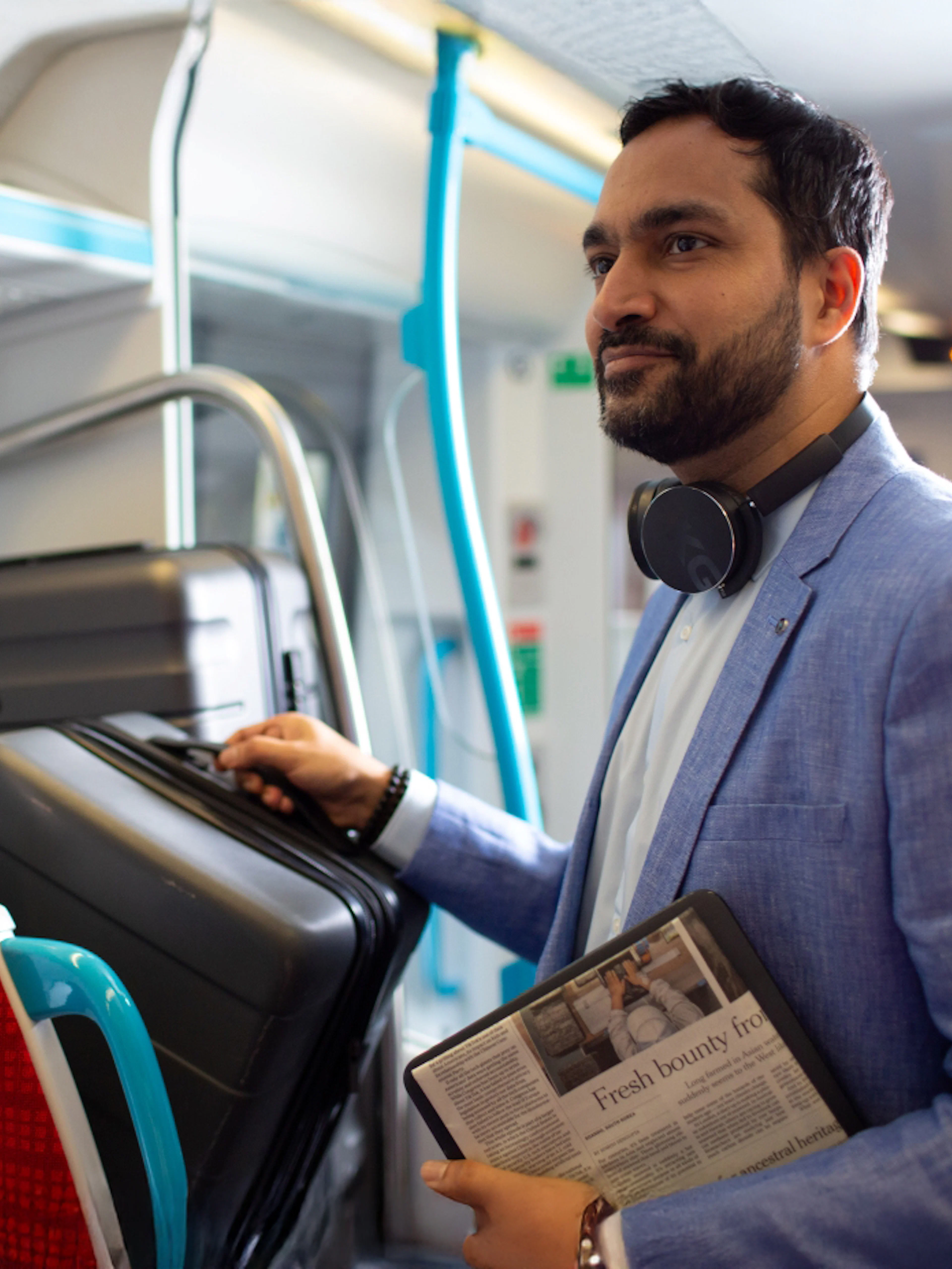 Man placing luggage on train rack, Gatwick Airport (LGW) day train.