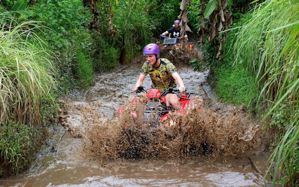 Quad biking through muddy trails in Bali.