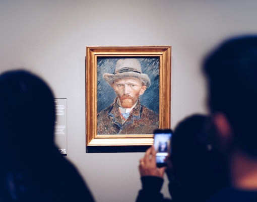 Visitors viewing a Van Gogh self-portrait at the Van Gogh Museum.