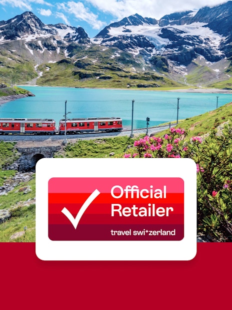 Train traveling through Swiss Alps near a turquoise lake with mountains in the background.