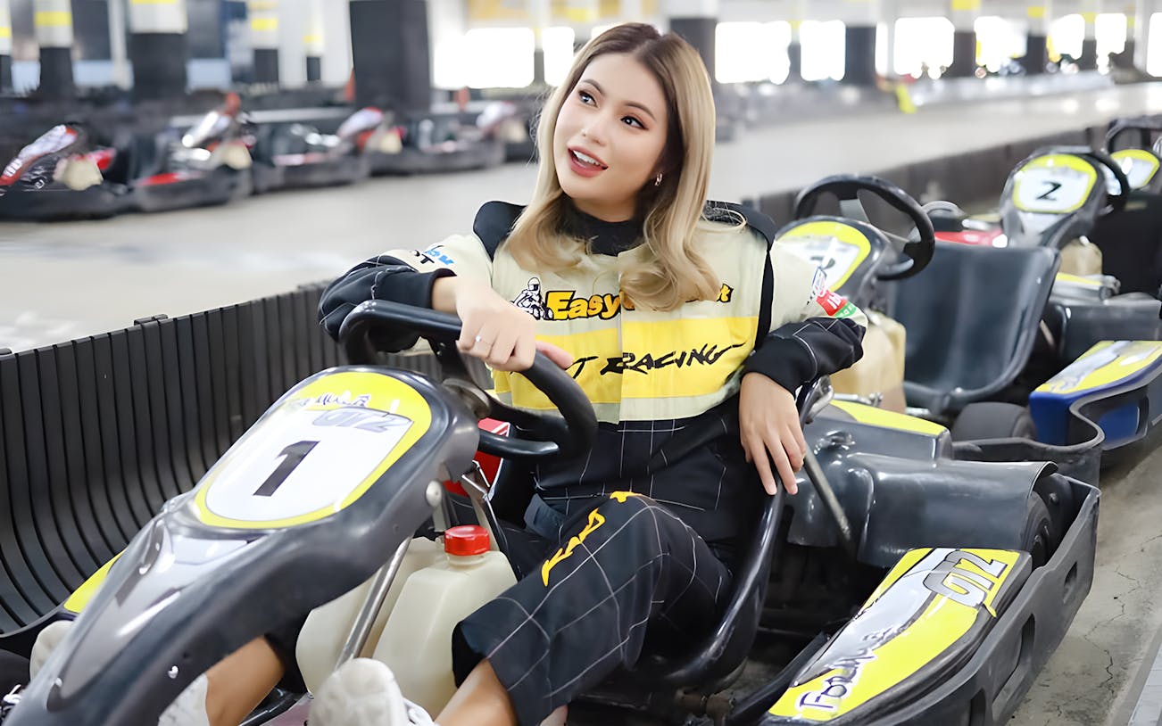 Woman sitting in a go-kart at an indoor track in Bangkok.