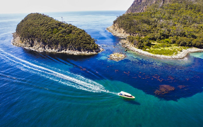 Boat navigating between lush islands on Bruny Island, Tasmania.