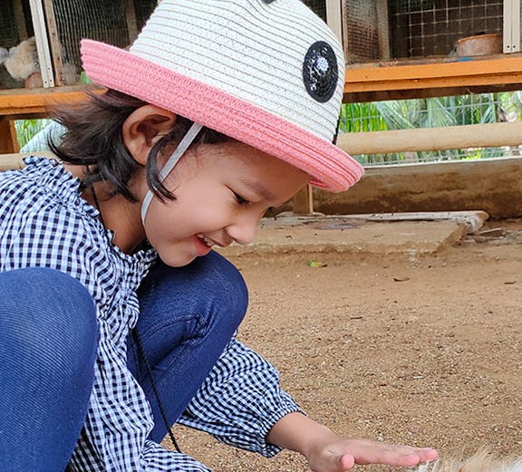 Child petting a rabbit at Melaka Crocodile & Recreational Park.