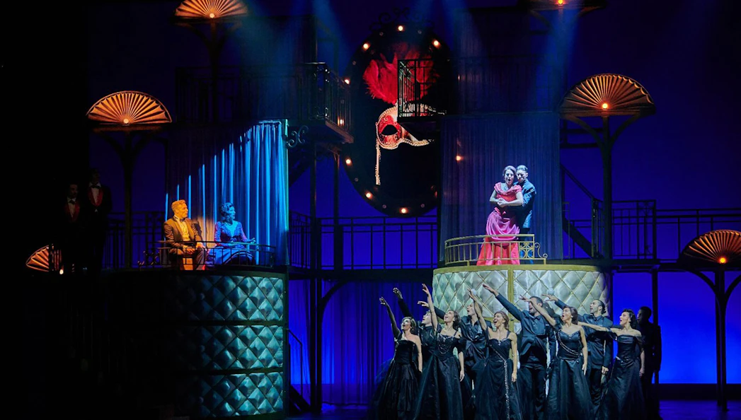 Stage scene from "Pretty Woman - El musical" with performers in elegant attire.