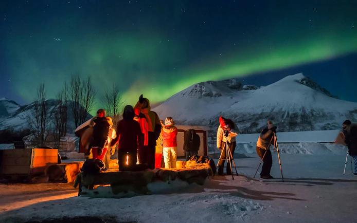 Group observing Northern Lights at a safari camp in Tromsø, Norway.