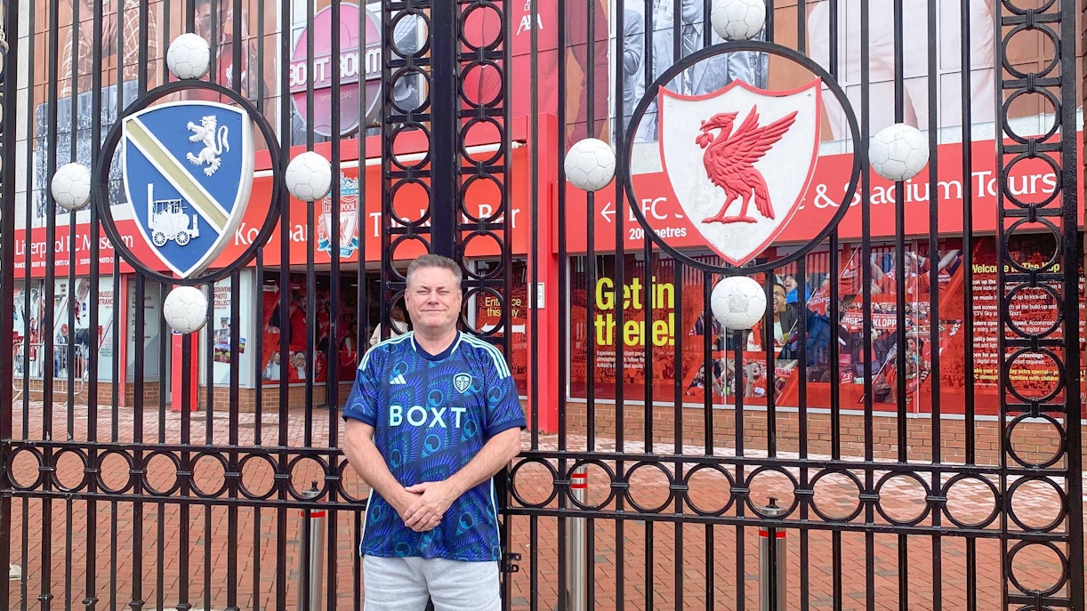 Shankly Gates at Liverpool FC stadium entrance, featuring iconic "You'll Never Walk Alone" sign.