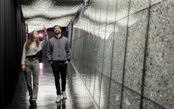 Visitors exploring a sparkling corridor at Swarovski Crystal Worlds.