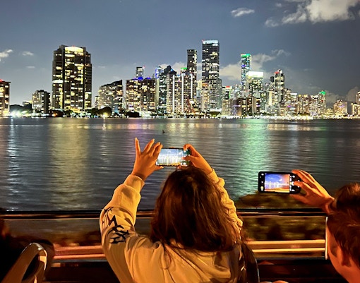 Passengers enjoying the Big Bus Miami Panoramic Night Bus Tour, viewing Miami's illuminated skyline and landmarks