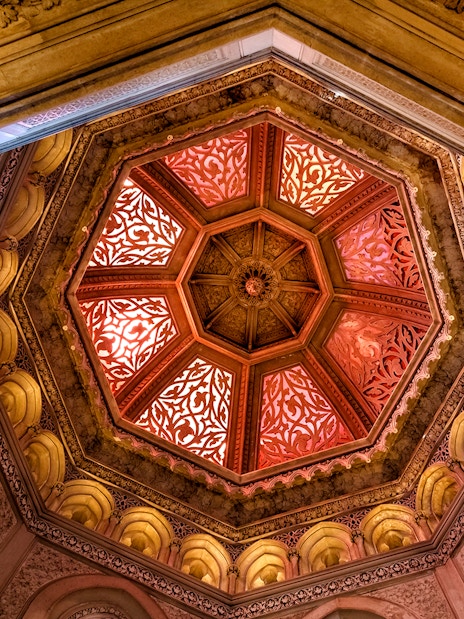 Ornate ceiling of Monserrate Palace with intricate patterns and warm lighting.
