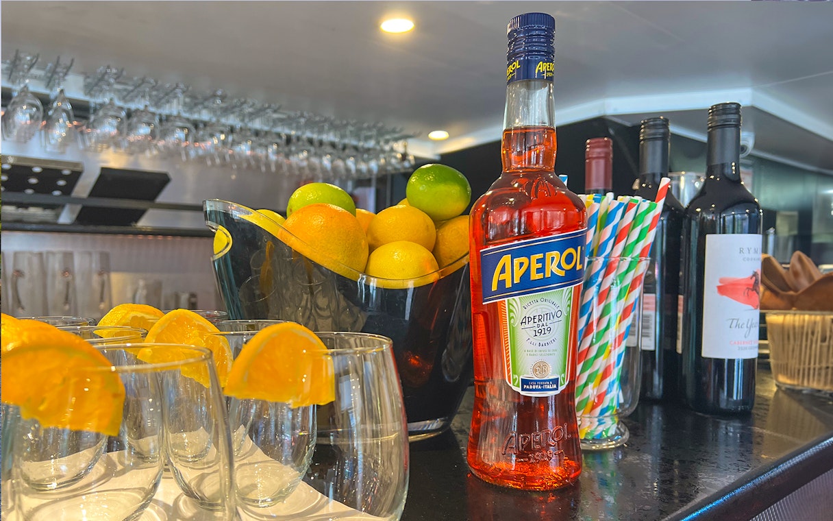 Aperol bottle and citrus fruits on bar for Bottomless Brunch Cruise in Melbourne.