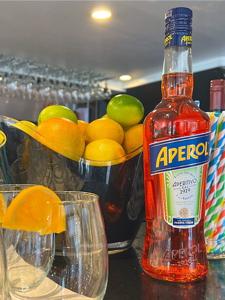 Aperol bottle and citrus fruits on bar for Bottomless Brunch Cruise in Melbourne.