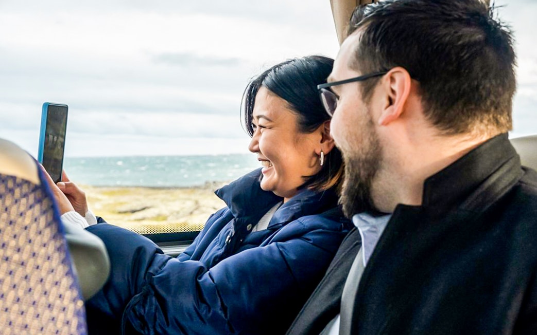 Passengers enjoying scenic views on a bus from Reykjavik Keflavik Airport to Reykjavik BSI Terminal.