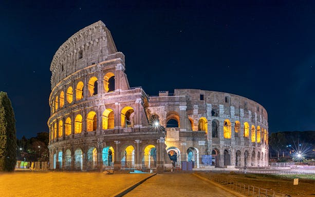 Colosseum illuminated at night in Rome, Italy.