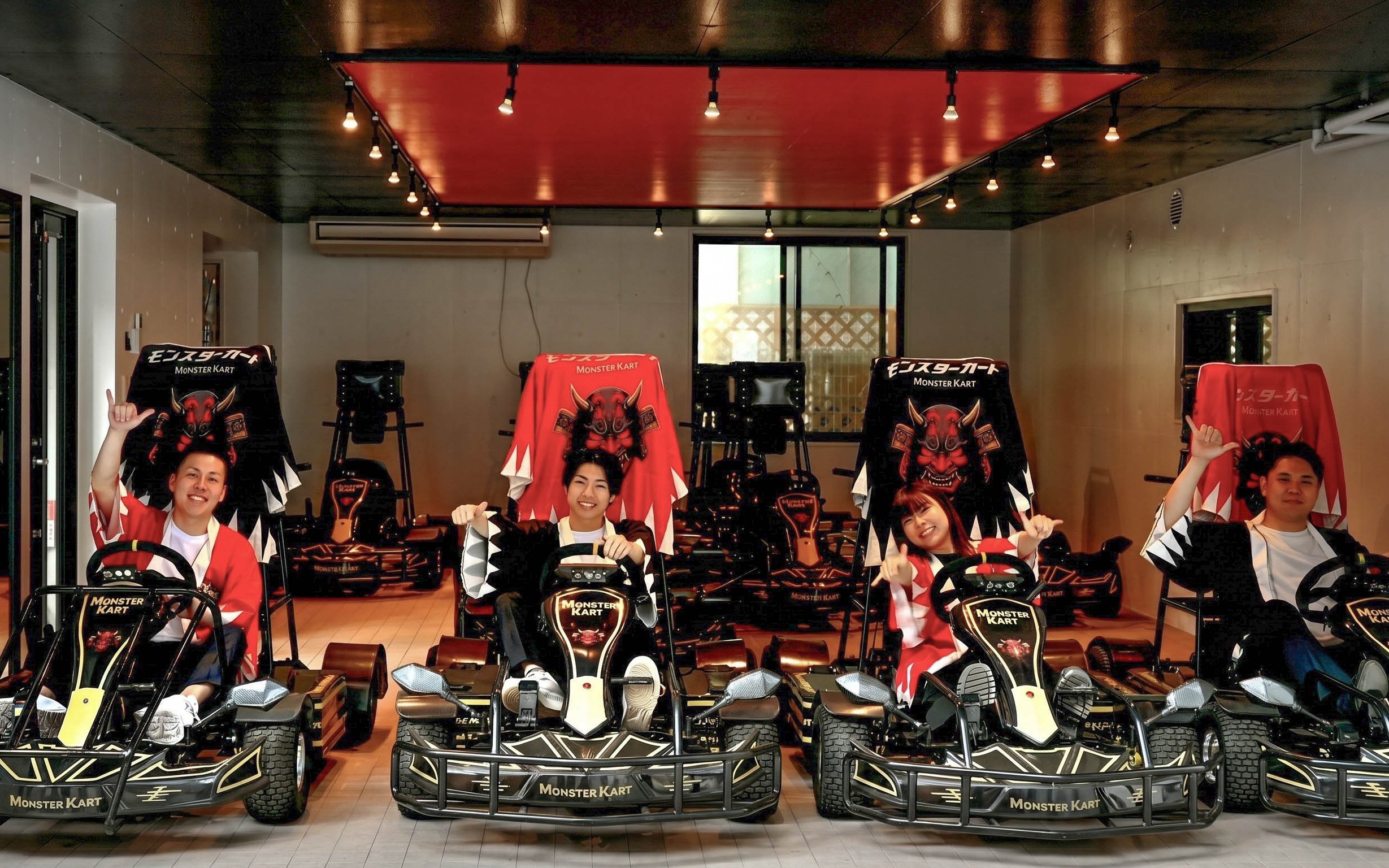 Street Kart participants in Tokyo posing in themed go-karts indoors.