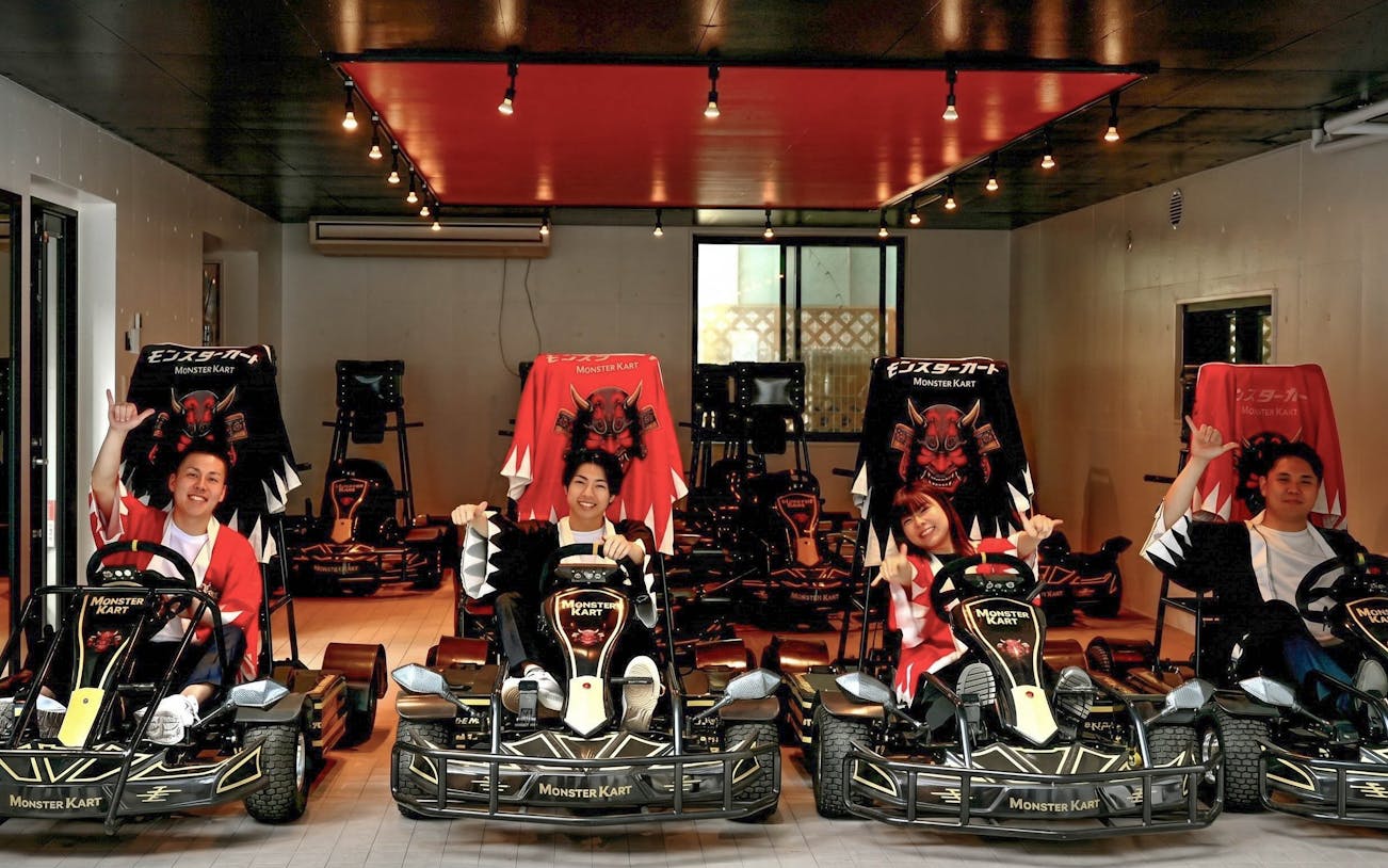 Street Kart participants in Tokyo posing in themed go-karts indoors.