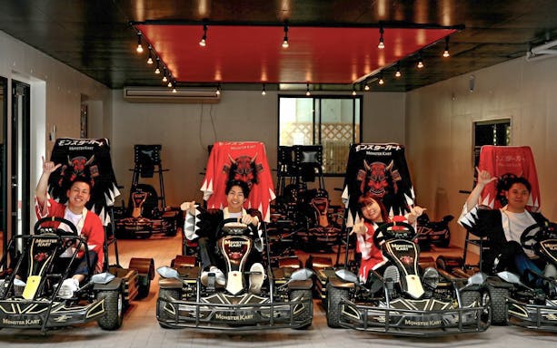 Street Kart participants in Tokyo posing in themed go-karts indoors.