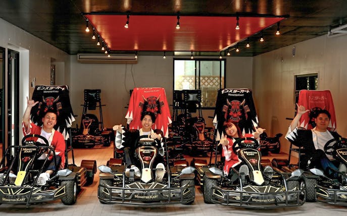Street Kart participants in Tokyo posing in themed go-karts indoors.