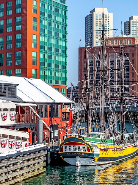 Boston Tea Party Ship docked near historic buildings and waterfront.