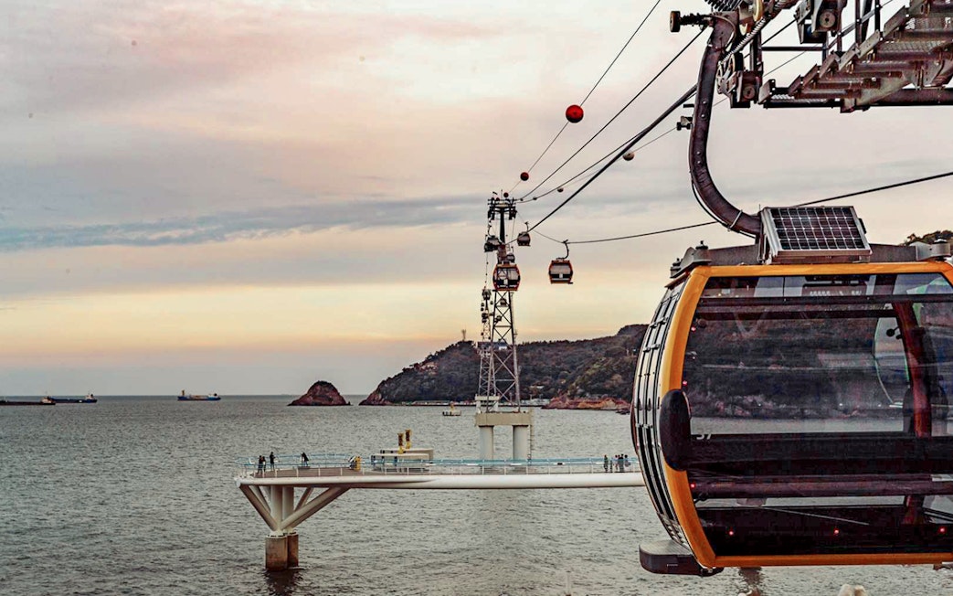 Songdo Marine Cable Car over ocean in Busan at sunset.