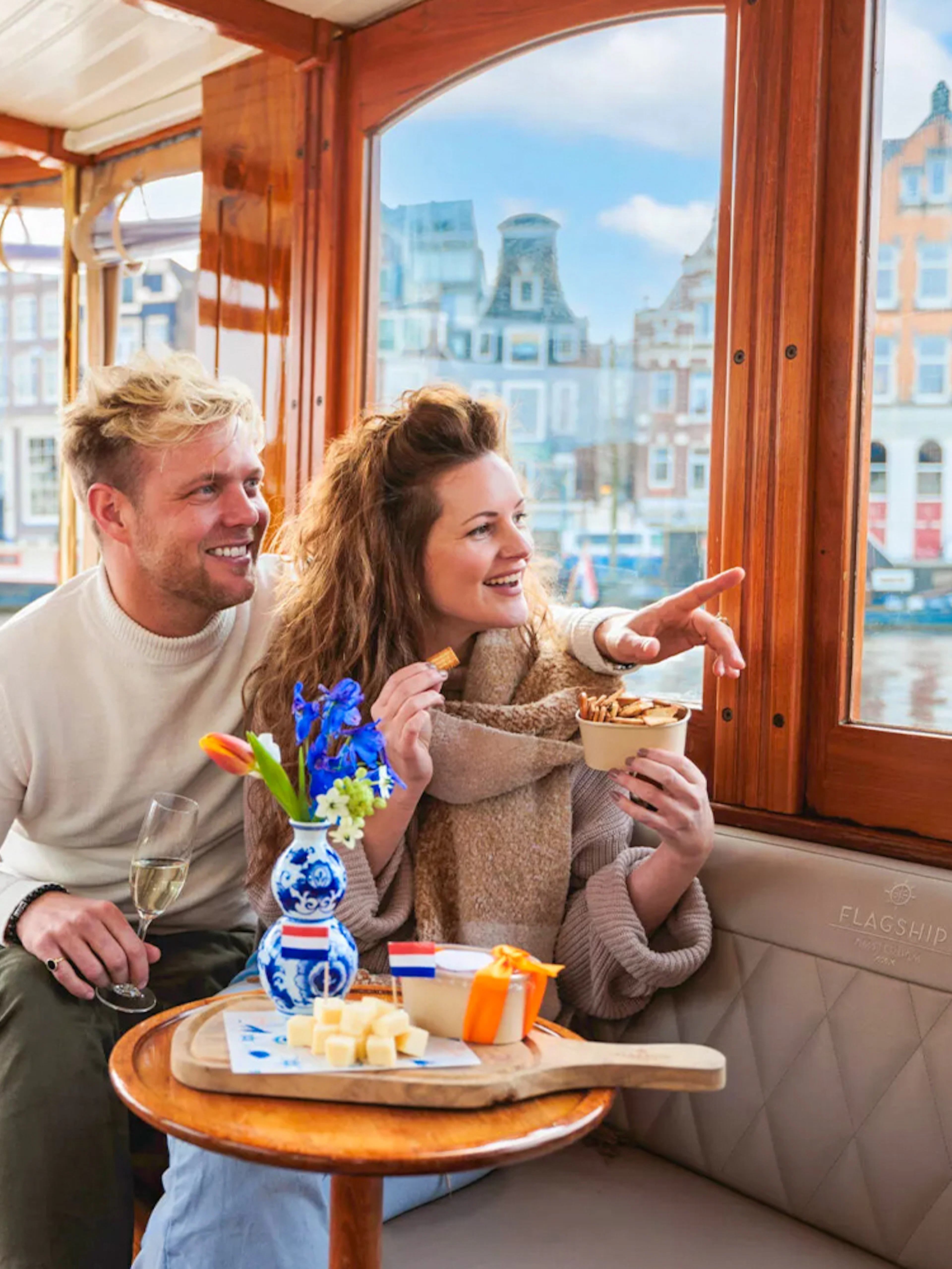 Couple enjoying a luxury romantic cruise in Amsterdam with city views.
