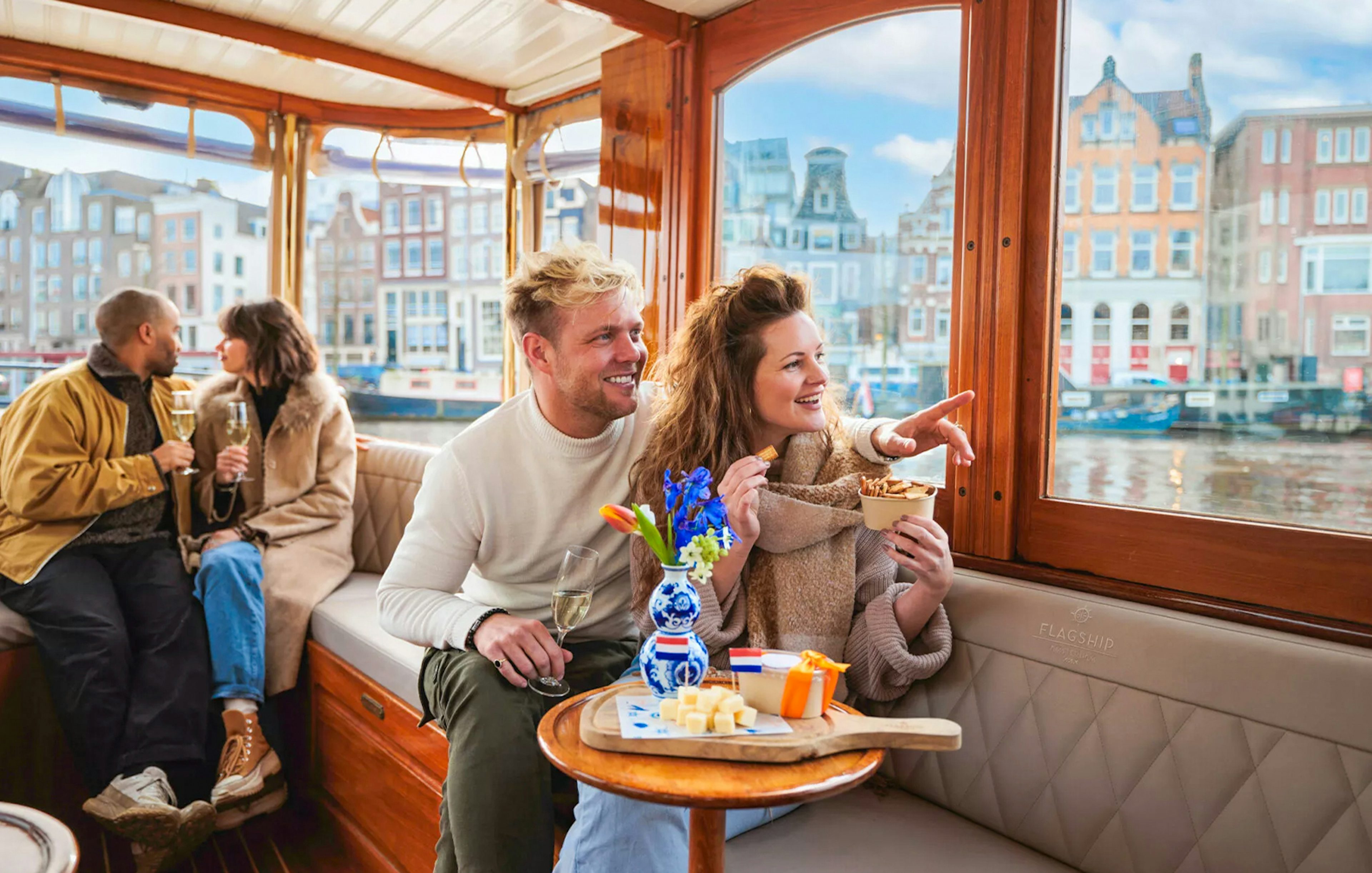 Couple enjoying a luxury romantic cruise in Amsterdam with city views.