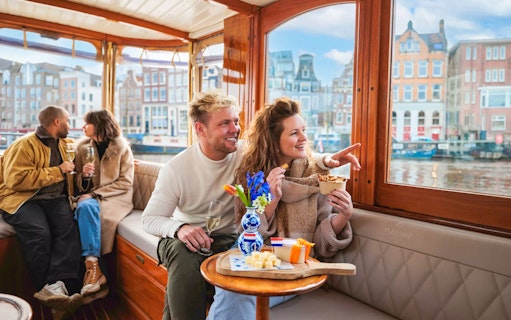 Couple enjoying a luxury romantic cruise in Amsterdam with city views.