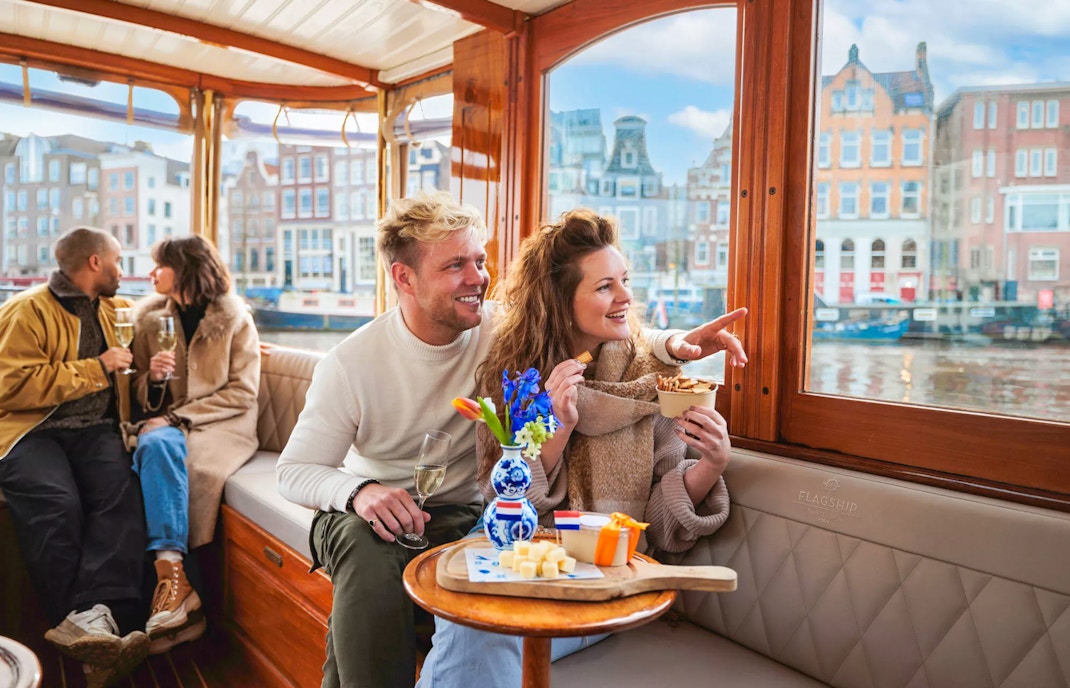 Couple enjoying a luxury romantic cruise in Amsterdam with city views.