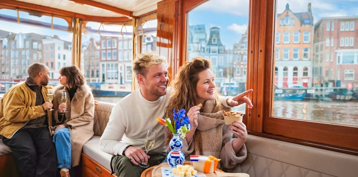 Couple enjoying a luxury romantic cruise in Amsterdam with city views.