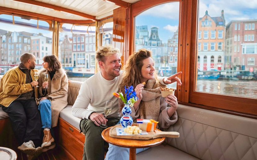 Couple enjoying a luxury romantic cruise in Amsterdam with city views.